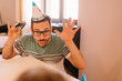 © Nebojsa - Young father with party hat wants to make photo of his daughter with his camera so he making funny faces to make her smiling