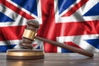 Wooden gavel and flag of UK on background - law concept