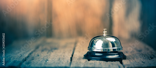 Fotomural Bell metal service on wood ground with blurred wooden background