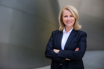 pretty older business woman, successful confidence with arms crossed in financial building