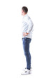 © sharplaninac - Side view of young man in light blue shirt and jeans with hands on hips looking behind. Full body isolated on white background.