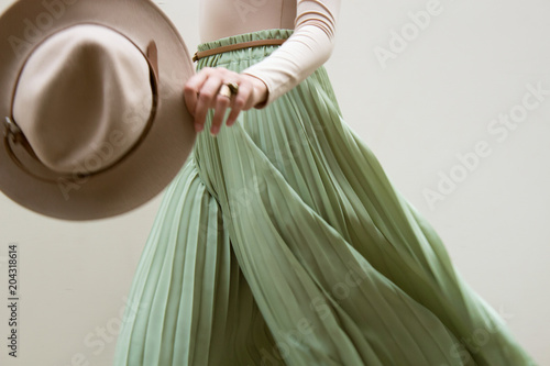 Fotomural Hat, beige blouse and turqoise pleats skirt on light street backgraund