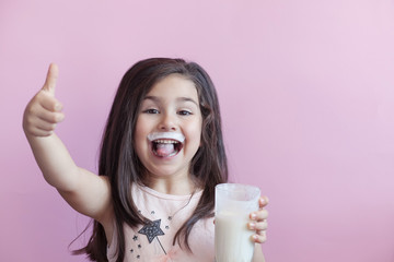 Wall Mural - Happy child girl drinking yogurt. Whiskers from yogurt.