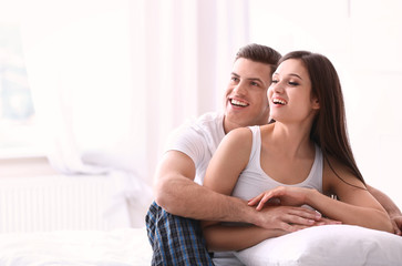 Sticker - Young couple on bed with soft pillows at home