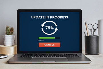 Update concept on laptop screen on modern desk. All screen content is designed by me. Front view.