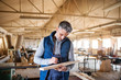 © Halfpoint - A man worker in the carpentry workshop, working with wood.