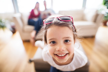 Wall Mural - Young happy child with parents in the background packing for holidays.