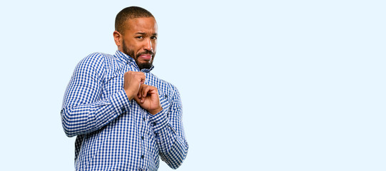 Canvas Print - African american man with beard disgusted and angry, keeping hands in stop gesture, as a defense, shouting isolated over blue background