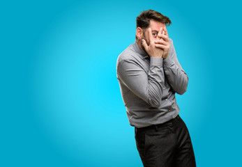 Canvas Print - Middle age man, with beard and bow tie smiling having shy look peeking through fingers, covering face with hands looking confusedly broadly