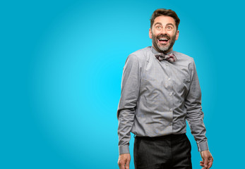 Canvas Print - Middle age man, with beard and bow tie happy and surprised cheering expressing wow gesture