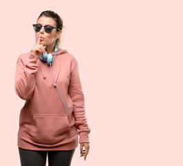 Wall Mural - Young sport woman with headphones and sunglasses terrified and nervous expressing anxiety and panic gesture, overwhelmed