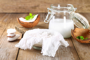 Squeezing milk from the chips of coconut in the gauze on an old wooden table.