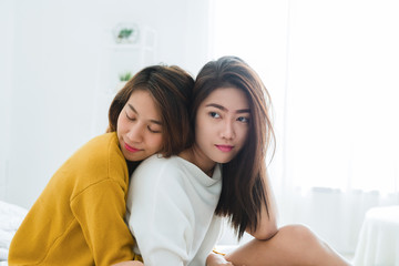 Wall Mural - Beautiful young asian women LGBT lesbian happy couple sitting on bed hugging and smiling together in bedroom at home. LGBT lesbian couple together indoors concept. Spending nice time at home.