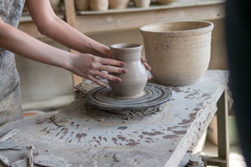 potter sculpts a vase on a potter's wheel