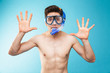 Portrait of a cheerful young shirtless man in swim goggles