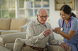 © Erickson Stock - Smiling female nurse showing an elderly patient his result on a thermometer.