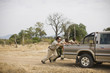 © Erickson Stock - Three mid-adult men pushing a truck along a dirt road.