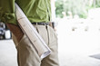 © Mint Images - Landscape architect holding plans for a new yard design.