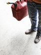© Mint Images - Landscape company employee standing in the company shop with a gas can in his hand.