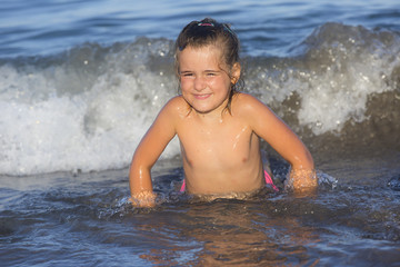 A girl on a waves on the sea in a sunny day