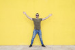 © 2Design - Man wearing sunglasses and posing against a yellow wall