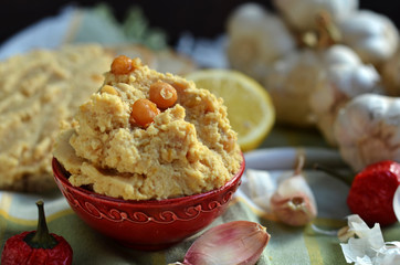 Hummus paste in small red bowl