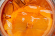 orange cocktail decorated with orange slice and ice. macro