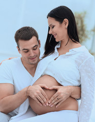 Poster - closeup .husband and pregnant wife putting their hands on her tummy.