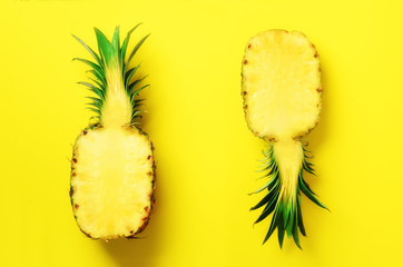 Wall Mural - fresh half sliced pineapple on yellow background. top view. copy space. bright pineapples pattern fo