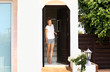 © lado2016 - Beautiful woman opening the door of her home.Inviting the guests