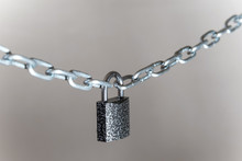 Closeup On Padlock Locking The Chain On Grey Background