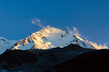 Sunset in mountains. Reflection of red sun on mountain snow peaks, Fann, Pamir Alay, Tajikistan