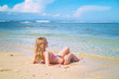 © astrosystem - Female lying on a sandy beach near the ocean / sea water.
