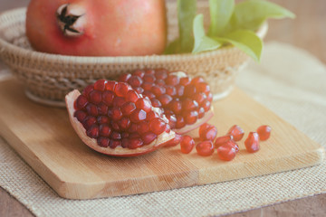 Wall Mural - Sweet and juicy Indian red pomegranate on wood table in side view with copy space. Delicious fruit which have high vitamin c and antioxidant for good skin. Healthy concept for background or wallpaper.