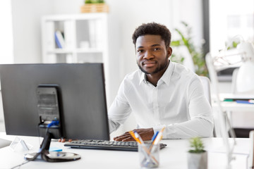 Wall Mural - business, people and technology concept - african american businessman with computer working at office