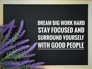 Motivational and inspirational quote - ‘Dream big, work hard, stay focused and surround yourself with good people’ written on a blackboard. With blurred vintage styled background.