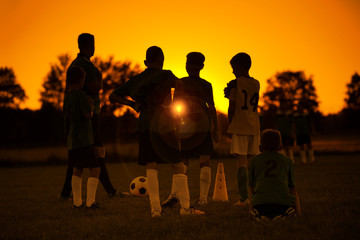 Sunset Soccer. Kids Soccer Football Team on Training with the Coach. Sports Soccer Practice at Sunset. Soccer Summer Camp for Sporty Children