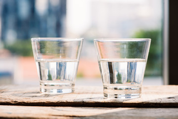 Two glasses of water on table on wooden background