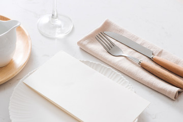 Table decoration. White plates, fork, knife on grey stone plate