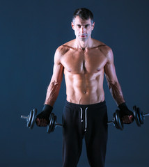 Handsome muscular man working out with dumbbells. Personal fitness instructor. Personal training.