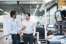 Two businessmen talking in modern factory