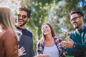 group of young people walking through park. friends having fun outdoor