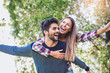 © Mediteraneo - Couple having fun man giving piggyback to woman in autumn park