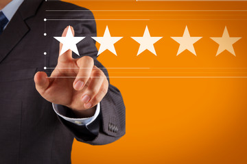 Five stars (5) rating with a businessman is touching virtual computer screen.For positive customer feedback and review with excellent performance.