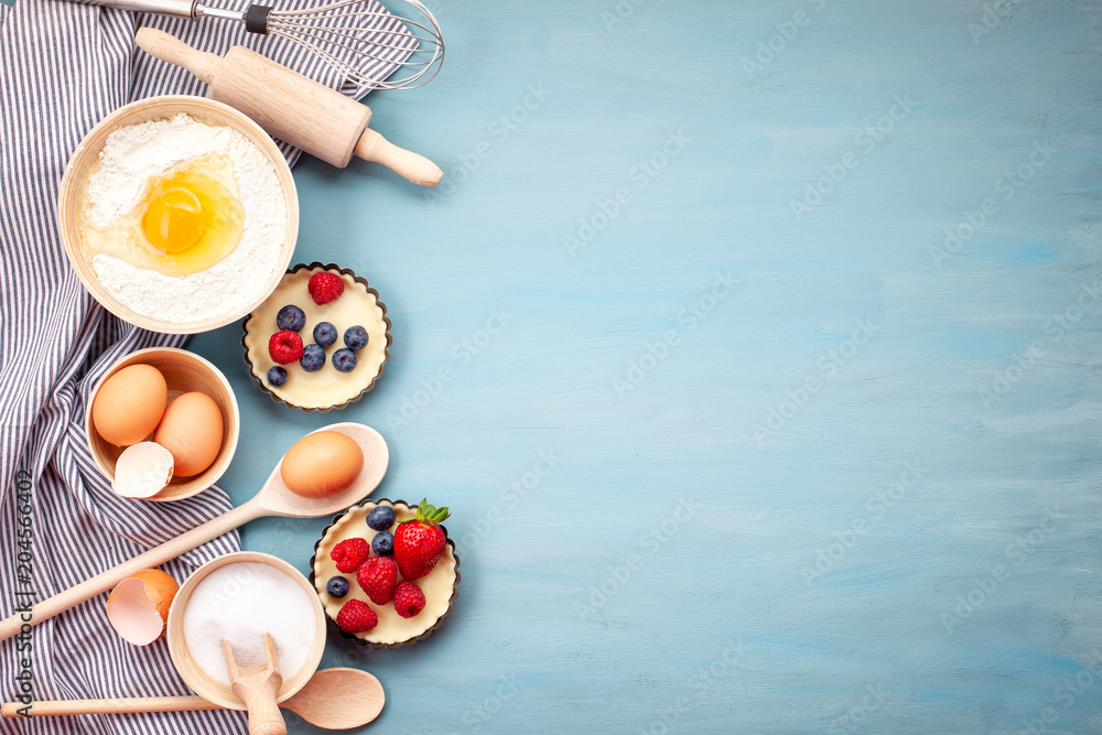 Baking utensils and cooking ingredients for tarts, cookies, dough and pastry. Flat lay with eggs, flour, sugar, berries.Top view, mockup for recipe, culinary classes, cooking blog. - obrazy, fototapety, plakaty 