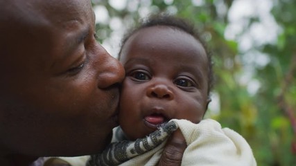 father kissing his little baby