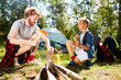 © pressmaster - Boy scout helping his father with preparing firewood for campfire on summer weekend