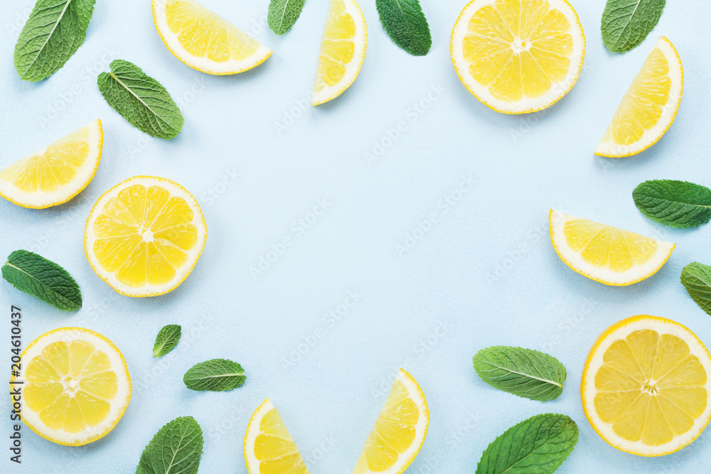 Frame from lemon slices and mint leaves on blue pastel table top view. Ingredients for summer drink and lemonade. Flat lay style. - obrazy, fototapety, plakaty 
