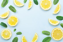 Frame From Lemon Slices And Mint Leaves On Blue Pastel Table Top View. Ingredients For Summer Drink And Lemonade. Flat Lay Style.