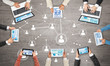 © adam121 - Top view of businesspeople sitting at table and using gadgets